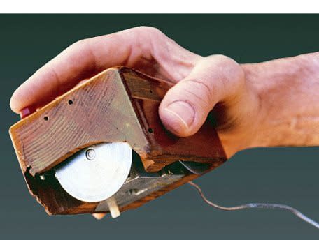 Doug Engelbart's original wooden mouse prototype held in a hand